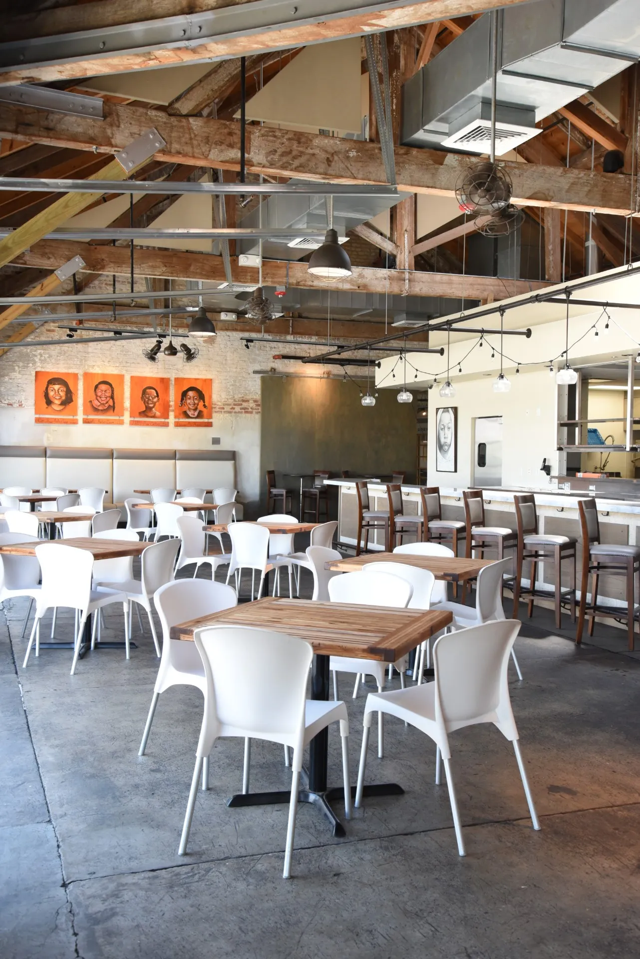 Spacious interior of Press Street Station featuring exposed beams, white seating, and a full-service bar